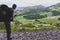 Tourist with big backpack and sticks on the top of Pyrenees mountains, toned. Pilgrim on Camino de Santiago, France.