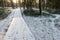 Tourist boardwalk with foot tracks on winter road