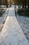 Tourist boardwalk with foot tracks on winter road