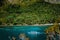 Tourist boat against jungle rainforest near beautiful tropical Snake island. El Nido, Palawan, Philippines