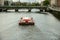 tourist boat crossing the liffey river through the center of Dublin heading