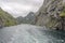 Tourist boat enters the wake of liner at narrow fjord , Trollfjord, Norway