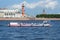 Tourist boat `Neman` with Asian tourists on the background of the spit of Vasilyevsky island