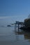 A tourist boat passes by a French fishing hut on stilts.