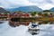 A tourist boat runs on the water at Ballstad Lofoten Island, Norway