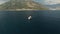 A tourist boat sails in the middle of the Bay of Kotor, in front of it is a mount and cozy town