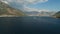 A tourist boat sails in the middle of the Bay of Kotor, in front of it is a mount and cozy town