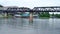 Tourist and boat under bridge of the River Kwai