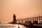 Tourist and boaters near South Haven`s lighthouse at sunset in Michigan