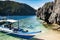 Tourist boats moored in a tranquil bay on turquoise waters of Sulu Sea.