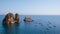 Tourist boats next to high cliffs on a calm mediterranean sea