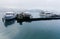 Tourist boats parking on peaceful water and moored to the floating docks of Shuishe Pier at Sun-Moon Lake on a foggy morning in Na