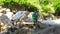 Tourist boy walking on wooden bridge over stony river while climbing in mountains. Boy tourist walking on hanging bridge