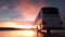 Tourist bus driving on a highway at sunset backlit by a bright orange sunburst. 3d rendering