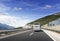 Tourist bus rushes along the country high-speed highway against the background of a mountain landscape.