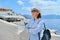 Tourist business, businesswoman posing of landscape of Oia Santorini