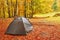 Tourist camp in the autumn forest with red and yellow foliage.