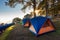 Tourist Camp Tent and Terrace Under Pine Trees Forest During Sunrise, Field Campground for Camping Vacation Adventure Outdoors and