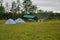 Tourist campground on a green meadow at the edge of the forest.