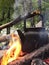 Tourist camping kettle on the fire boils on the background of the forest and the river. The romance camp