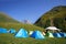 Tourist camping in the mountains of many tents and shelters for climbing to the top of the mountain - an alpine camp. Overnight in