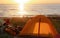 Tourist camping on the sand by the sea, yellow tent on the beach