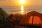 Tourist camping on the sand by the sea, yellow tent on the beach