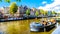 Tourist Canal Boats mooring at Anne Frank House at the Prinsengracht Prince Canal in the Jordaan neighborhood in Amsterdam