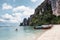 Tourist canoeing with wooden boat and mountain on coastline in tropical sea at Phi Phi Island