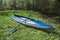 Tourist canoes with paddles stand on the river coast in summer on a water hike. Rafting on inflatable and frame double and triple