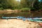 Tourist canoes with paddles stand on the river coast in summer on a water hike. Rafting on inflatable and frame double and triple