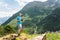 Tourist in a cap T-shirt and shorts with a tote with a phone in the hands in the mountains and trying to call somewhere