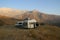 Tourist cars on the Pamir Highway between Murghab and Ak Baital pass, Gorno-Badakshan. Vintage van car parked on green hills. Trav