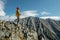 Tourist celebrate success by spreading their arms standing on background of mountains. Motivation and achievement