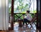 Tourist Chinese woman sit on chair at hotel room corridor while having leisure time in vacation