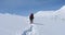 A tourist climbs a snowy slope