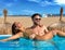 Tourist couple bath in infinity pool on a beach