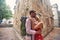 Tourist couple cuddling on street at summertime. Old buildings. European city. Young people on holiday. Date, honeymoon, love,