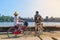 Tourist couple cycling in Angkor temple, Cambodia. Angkor Wat main facade reflected on water pond. Eco friendly tourism traveling