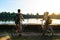 Tourist couple cycling in Angkor temple, Cambodia. Angkor Wat main facade reflected on water pond. Eco friendly tourism traveling