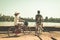 Tourist couple cycling in Angkor temple, Cambodia. Angkor Wat main facade reflected on water pond. Eco friendly tourism traveling