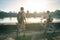 Tourist couple cycling in Angkor temple, Cambodia. Angkor Wat main facade reflected on water pond. Eco friendly tourism traveling