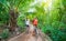 Tourist couple riding bicycle in the Mekong Delta region, Ben Tre, South Vietnam. Woman and man having fun cycling on trail among