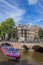 Tourist cruiseboat in the canals of historical Amsterdam