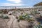 Tourist destination landscape, West Falkland island beach scene with yellow sea cabbage, people watching penguins at waterâ€™s edg