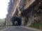 Tourist driver driving through tunnel on road carved out of rock of mountain