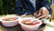 A tourist eats in an open-air summer cafe from plastic dishes.