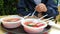 A tourist eats in an open-air summer cafe from plastic dishes.