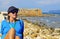 A tourist enjoys a beautiful sunny October day admiring the old city from the port walls, Xania, Crete