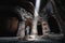 Tourist explores the mystical interior of the main hall of the Armenian Geghard Monastery. A ray of light falls on ancient